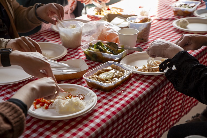 A group of people share food at the dining table