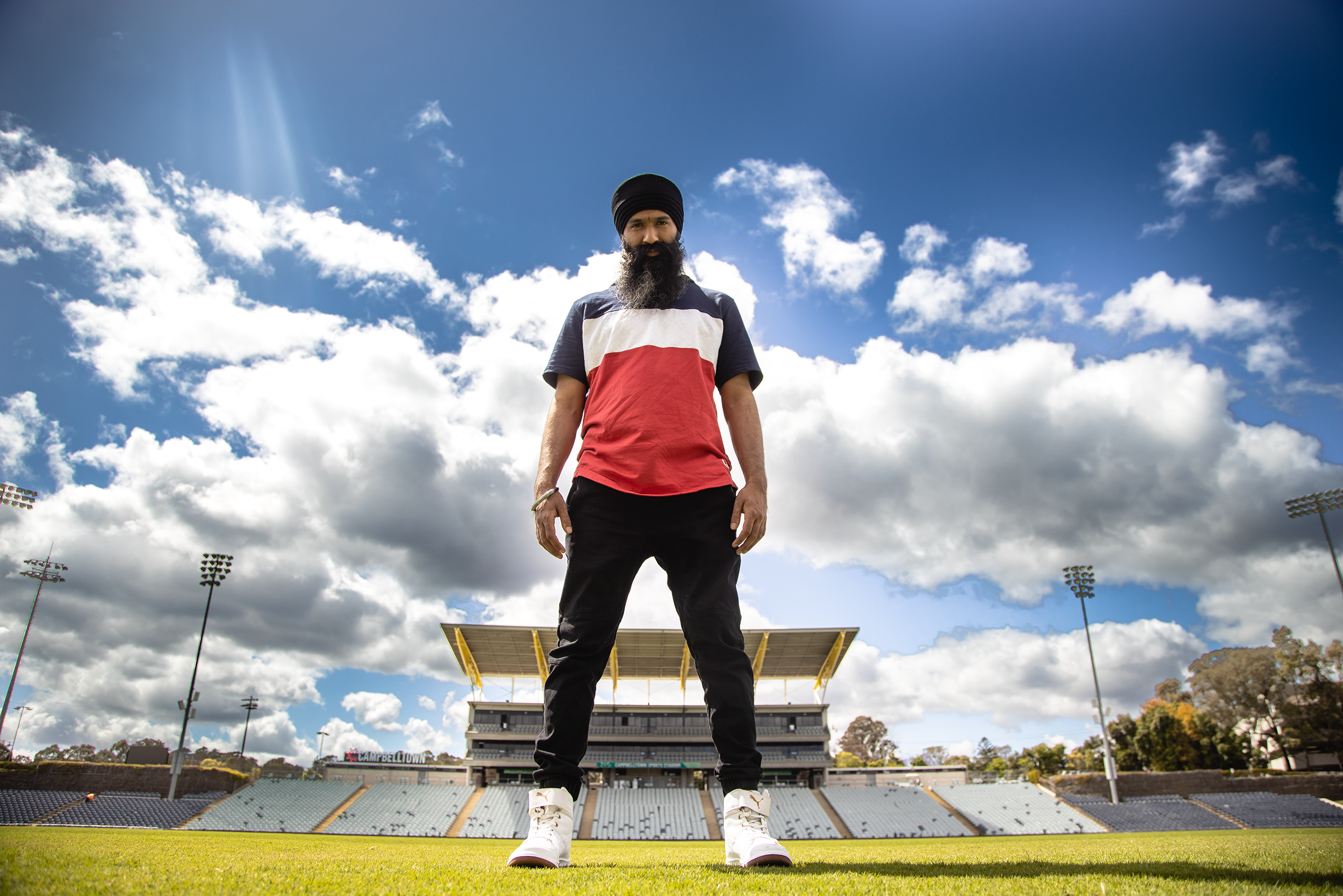 Hip Hop artist L-FRESH the LION smiling and posing on a field